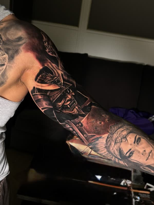 Dark full sleeve with warrior and woman's face over the elbow