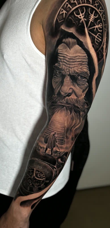 Viking full sleeve with weathered warrior portrait and runic compass